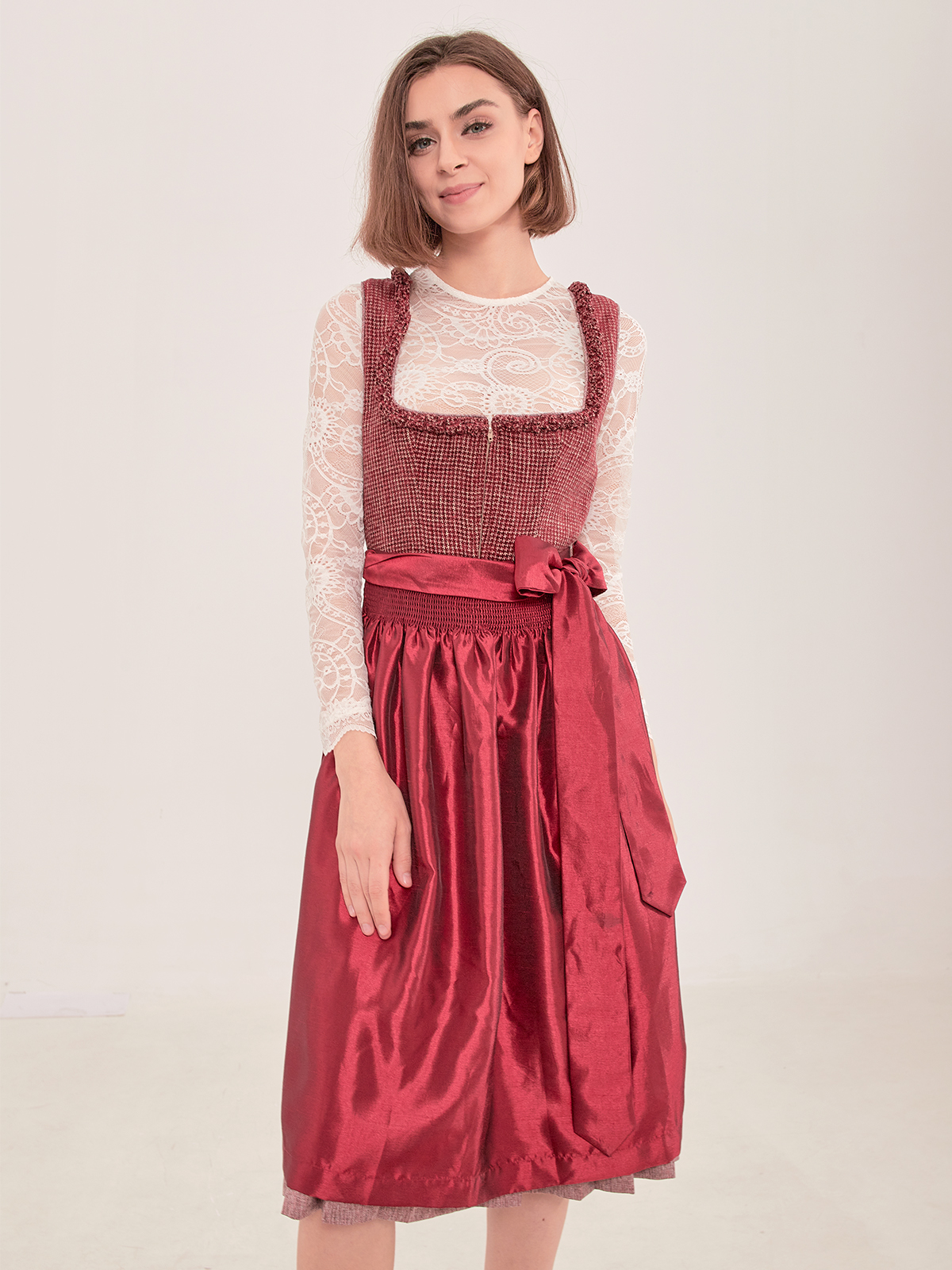 Ein elegantes rotes Dirndl mit traditioneller Schürze